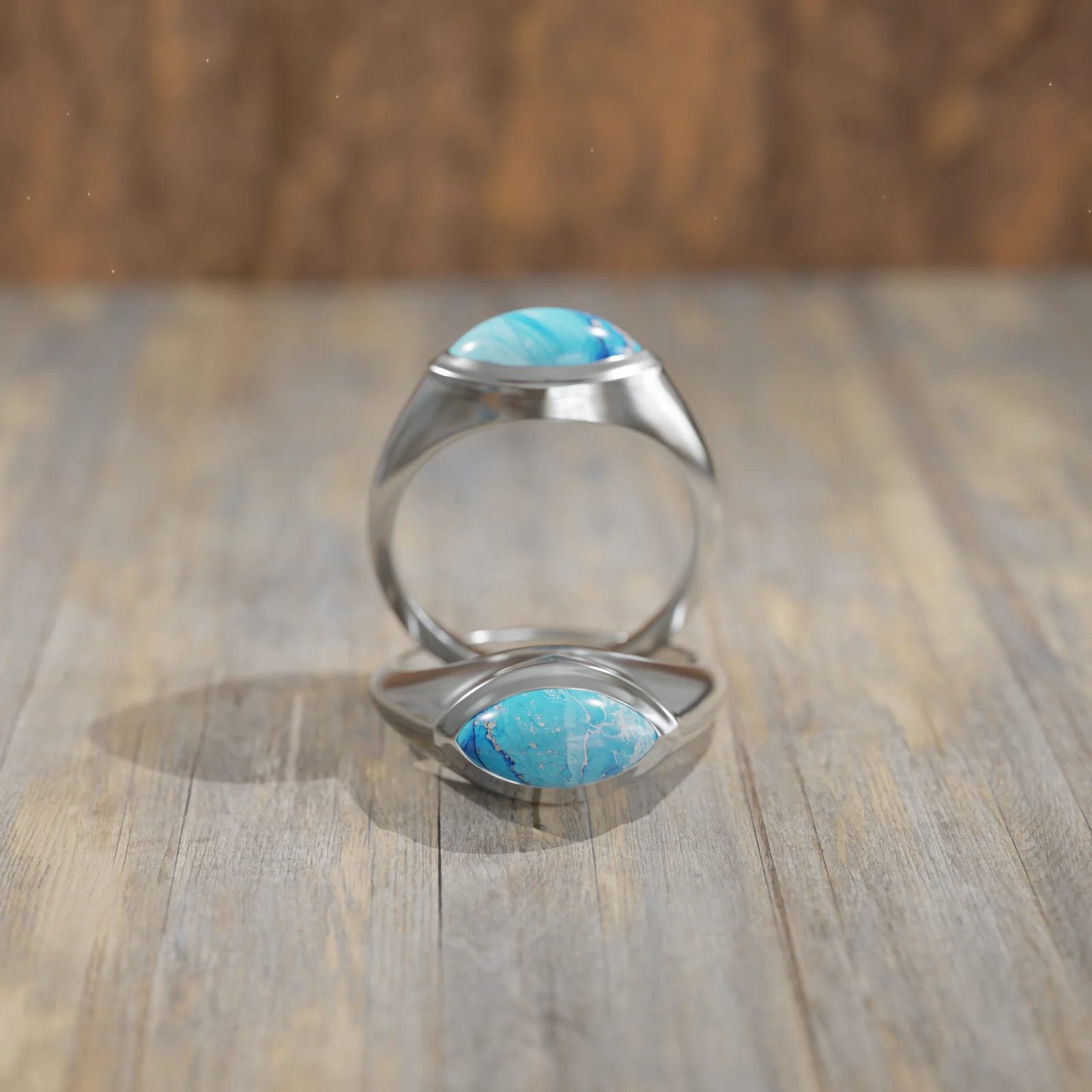A white gold turquoise signet photographed on walnut